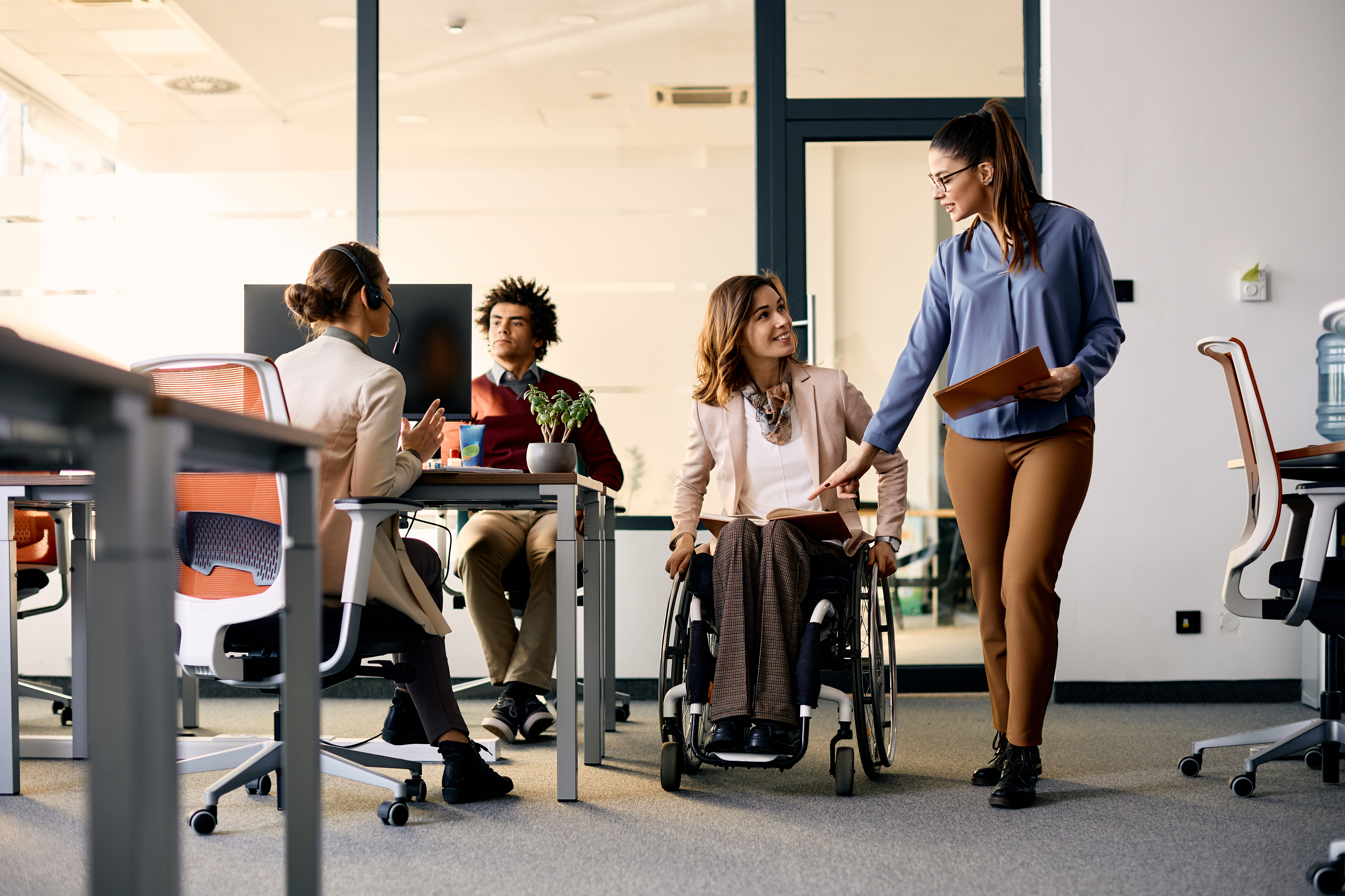 Equipe de trabalho, sendo uma das componentes, cadeirante.