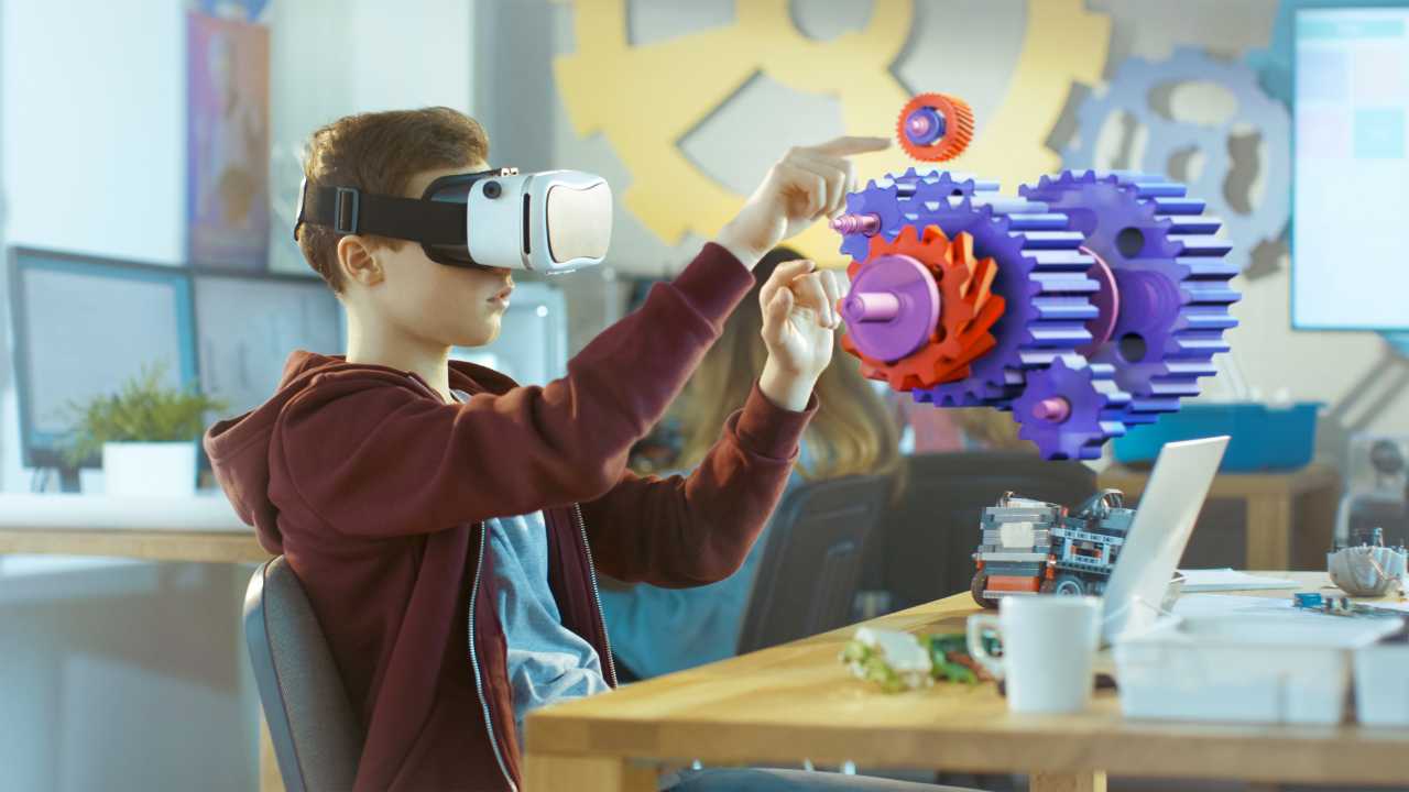 Uma criança utilizando um óculos de realidade virtual tentando pegar objetos fictícios