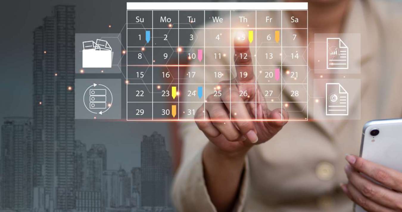 A imagem retrata uma pessoa (uma mulher) segurando um smartphone e fazendo anotações em um aplicativo de calendário. A tela do telefone exibe o calendário e uma notificação de compromisso. A mulher parece estar ocupada organizando sua agenda e planejando suas atividades, talvez como parte de seu trabalho como organizadora de eventos. 