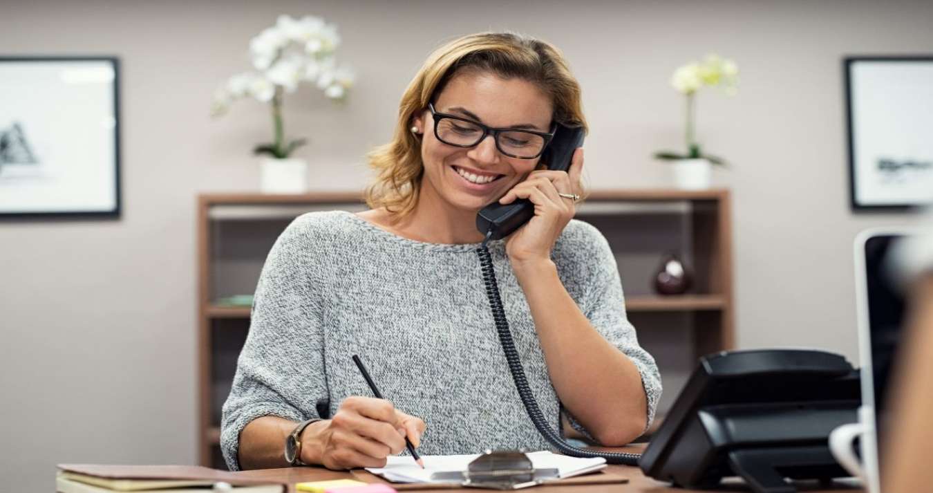 Mulher realizando atendimento ao telefone