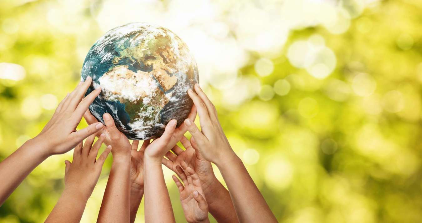 Indivíduos elevando conjuntamente o planeta Terra com as suas mãos