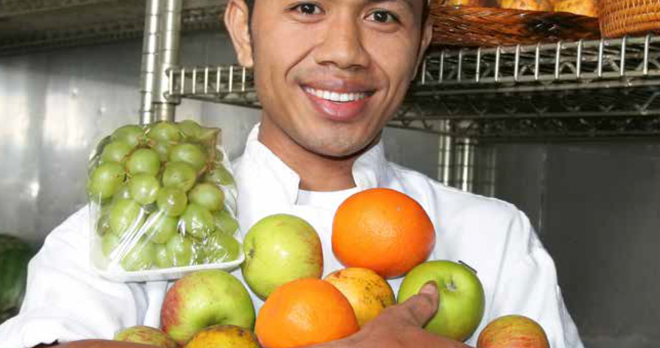 Homem com frutas nas mãos.