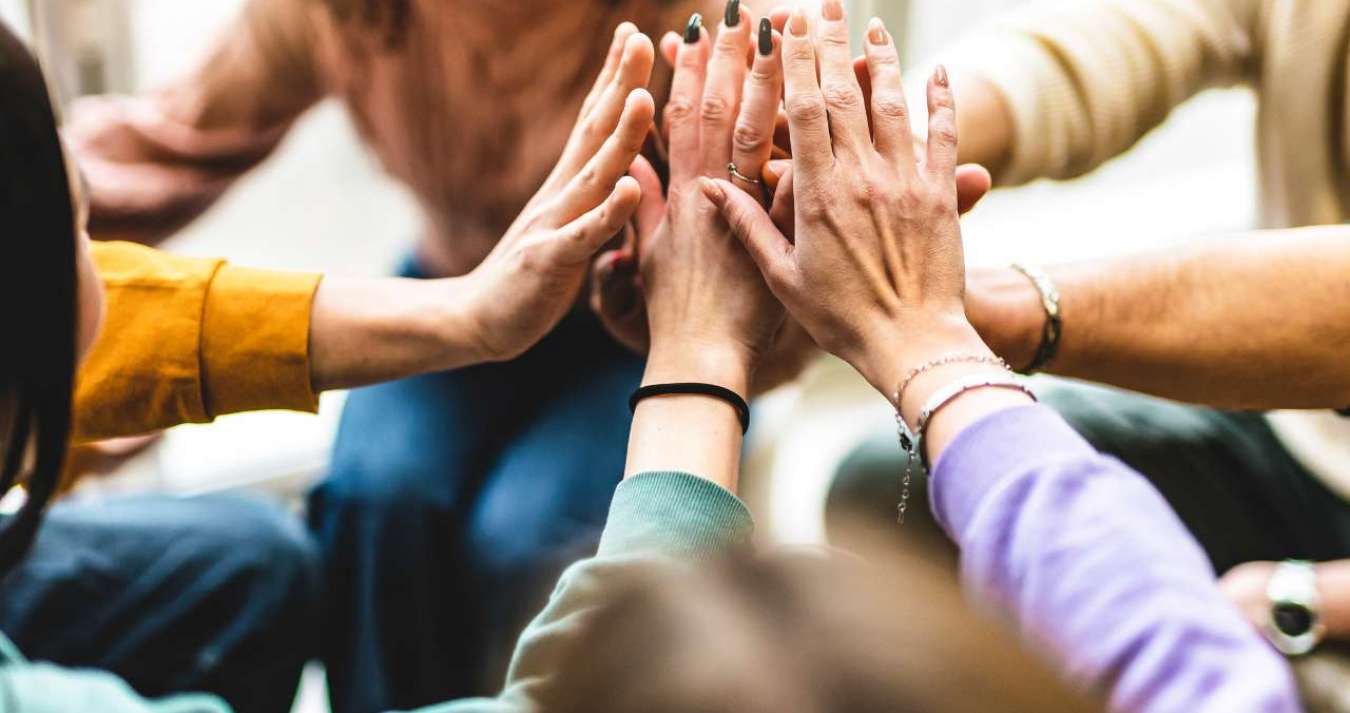 Amigos diversos e felizes unidos à mesa da comunidade se divertindo