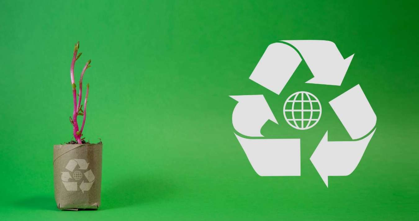 A imagem retrata o conceito de reciclagem e sustentabilidade ambiental, apresentando elementos relacionados à reutilização, fabricação de resíduos, consumo consciente de recursos e desenvolvimento sustentável