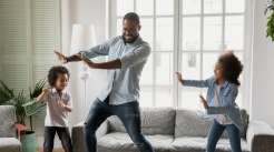 pai dançando com seus dois filhos