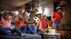 Grupo de pessoas assistindo animadamente a um jogo de futebol