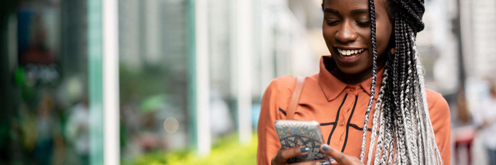 Mulher digitando no celular e andando