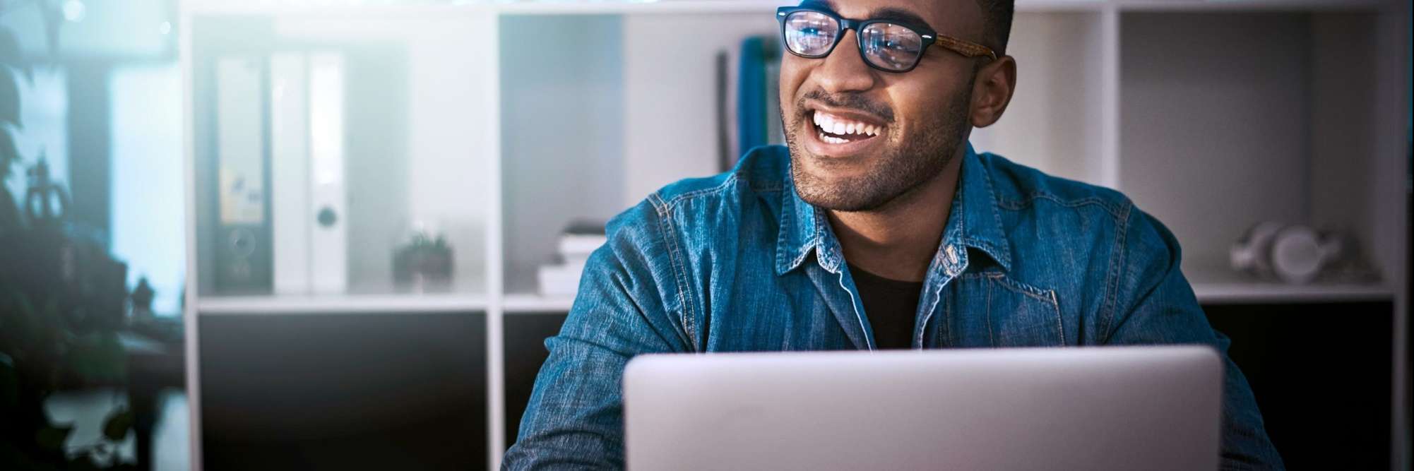 Homem sorrindo e teclado no laptop