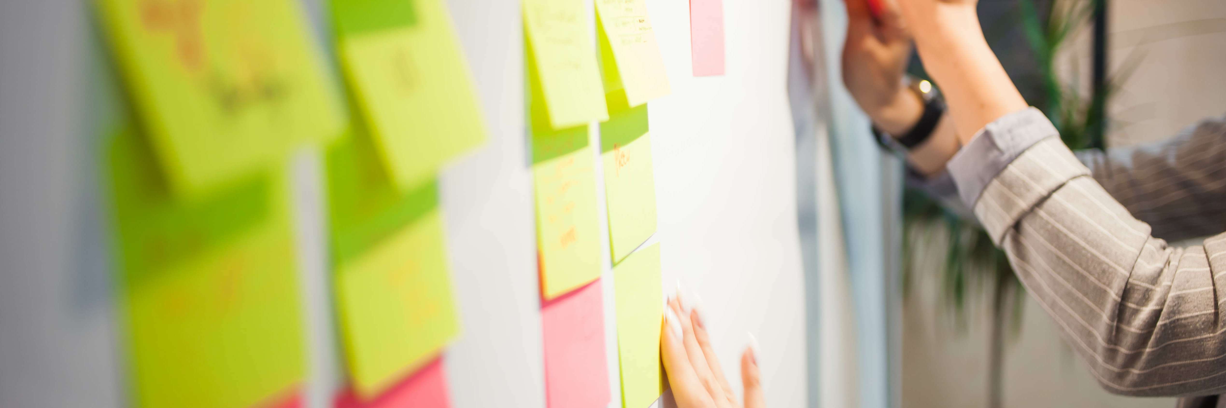 Post-Its sendo organizados por uma equipe.