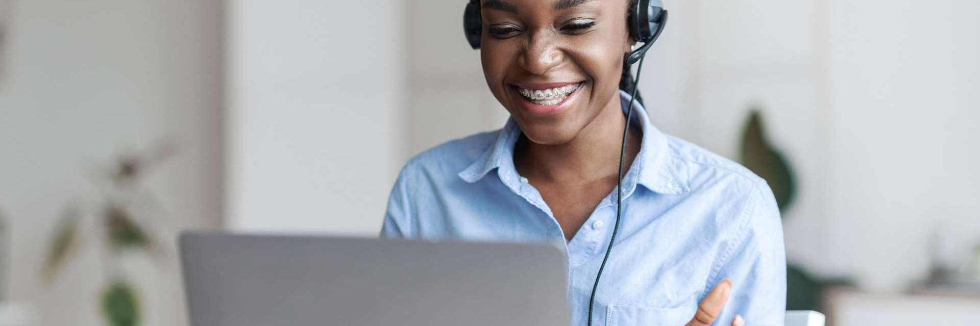 Mulher em frente a uma tela de notebook, possivelmente em uma reunião ou tutoria onlie