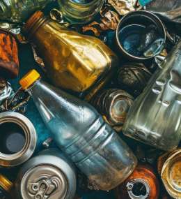 Uma pilha de latas, garrafas e outros lixos.